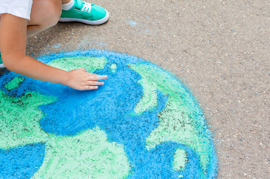 Young artist drawing the world with chalk