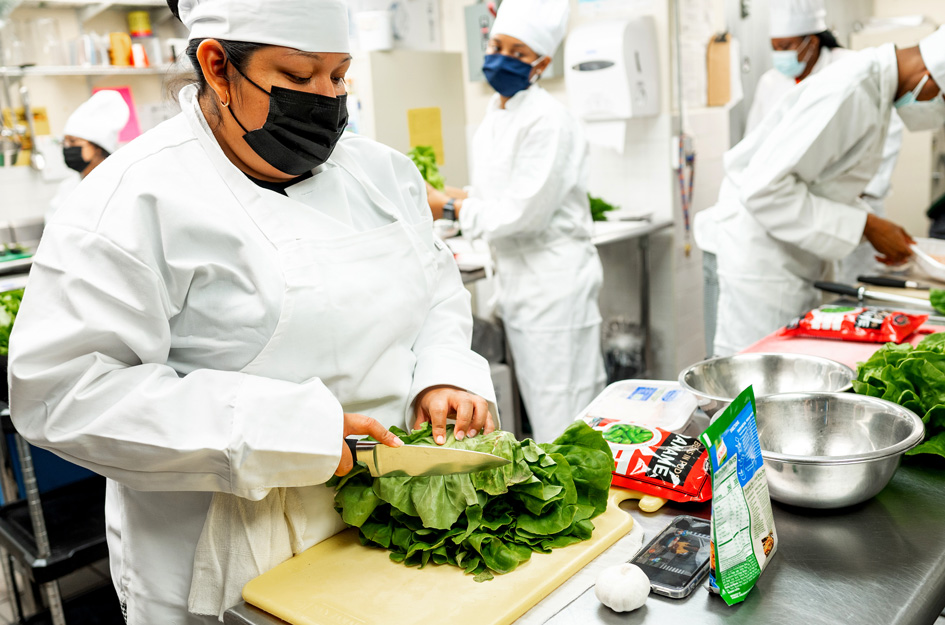 Student chef chopping lettuce