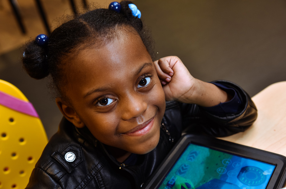 Cute smiling Black girl with tablet